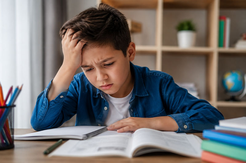 Niño preocupado haciendo sus tareas